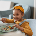 smiling-girl-eating-food-at-the-table-2026-09-22-06-37-15-utc