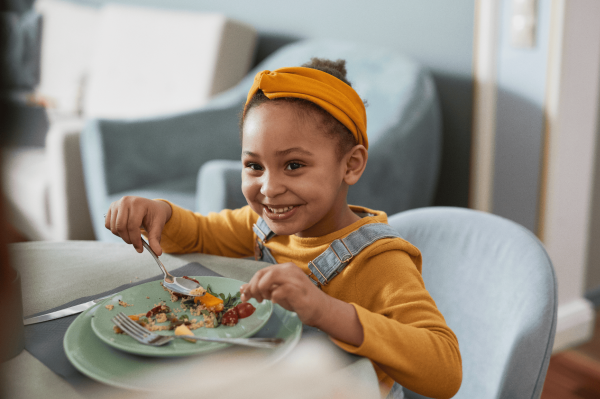 smiling-girl-eating-food-at-the-table-2026-09-22-06-37-15-utc