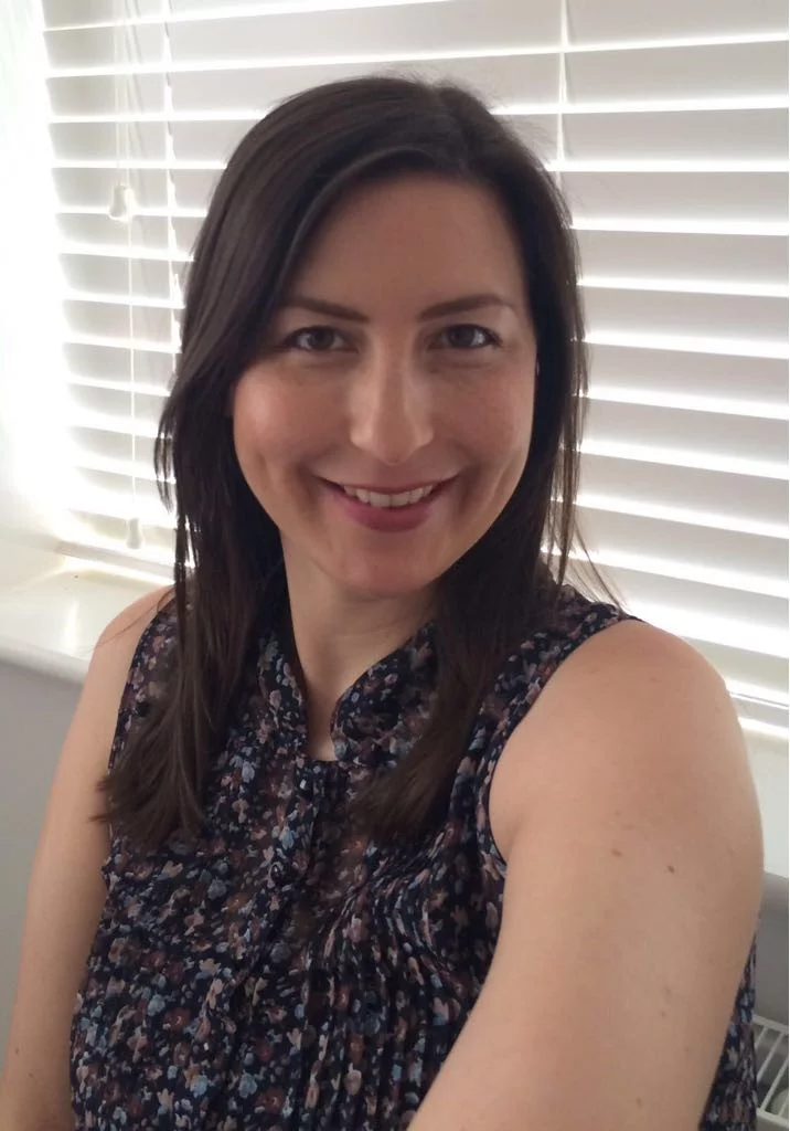 middle aged woman with dark hair smiling at the camera