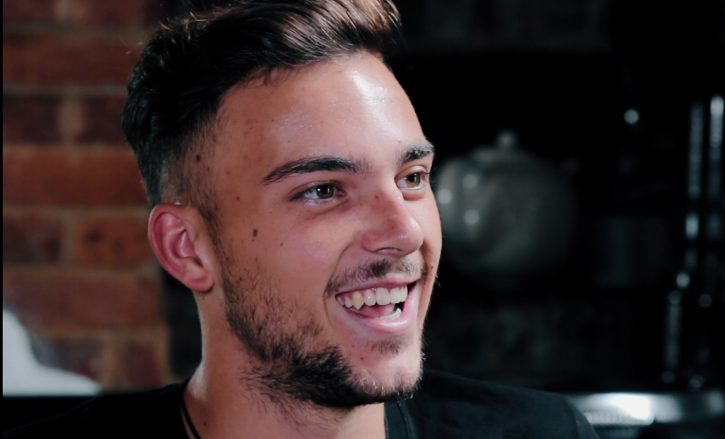 young man smiling and looking away from the camera