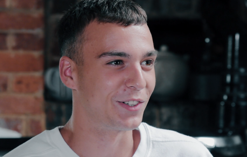 Young man wearing a white top looking away from the camera