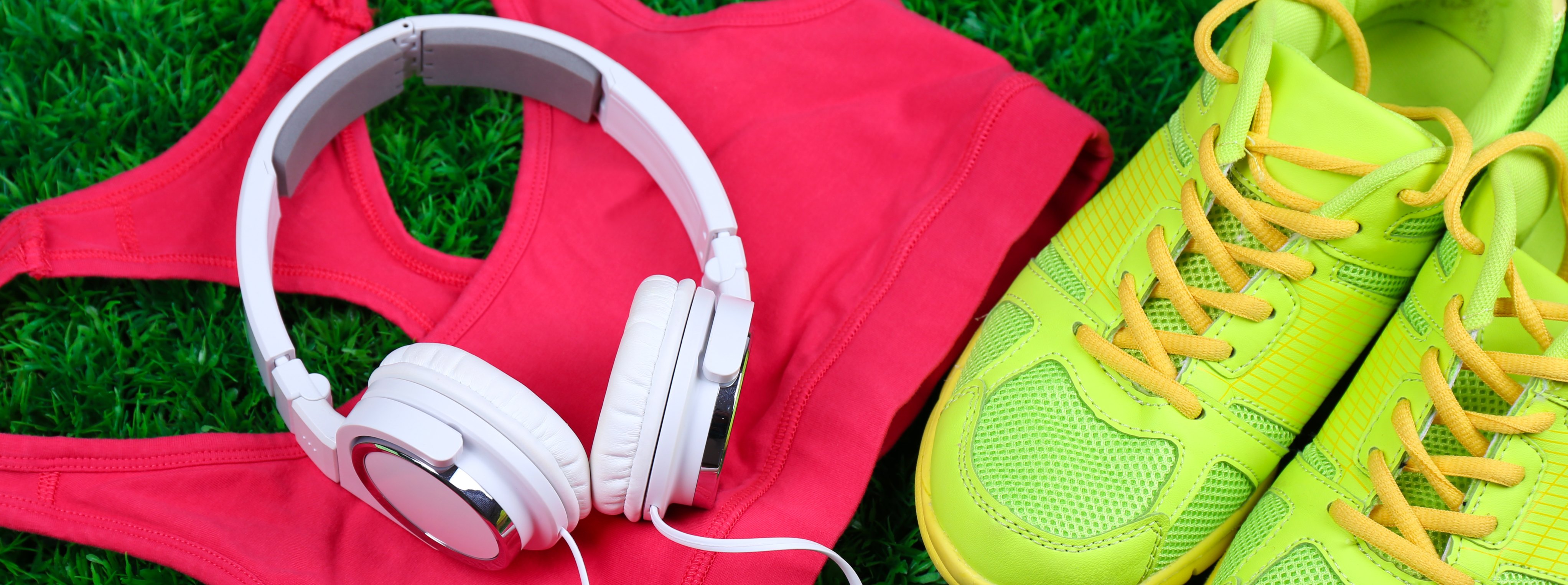 bright yellow running trainers, pink sports bra & white headphones