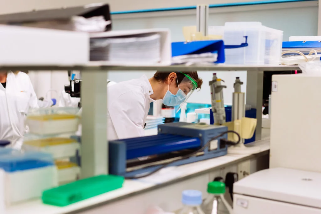 a young man with protective gear on working in a laboratory