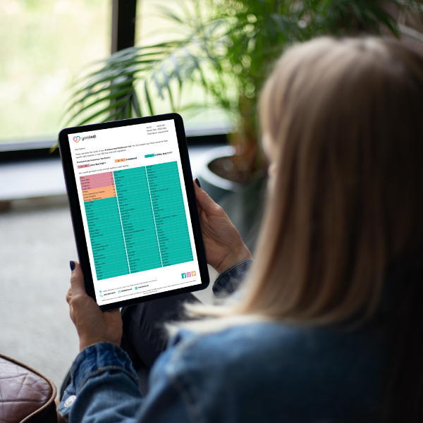 Woman facing with her back at the camera is reading the results of the Premium Food Intolerance Test on a generic black tablet.