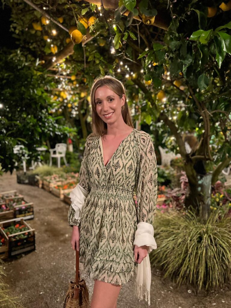 Young woman in an elegant cream dress posing for an evening picture in an outdoor venue